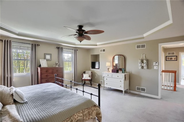carpeted bedroom with a raised ceiling, baseboards, and visible vents