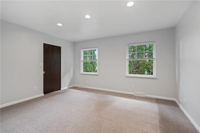 carpeted empty room with visible vents, recessed lighting, and baseboards