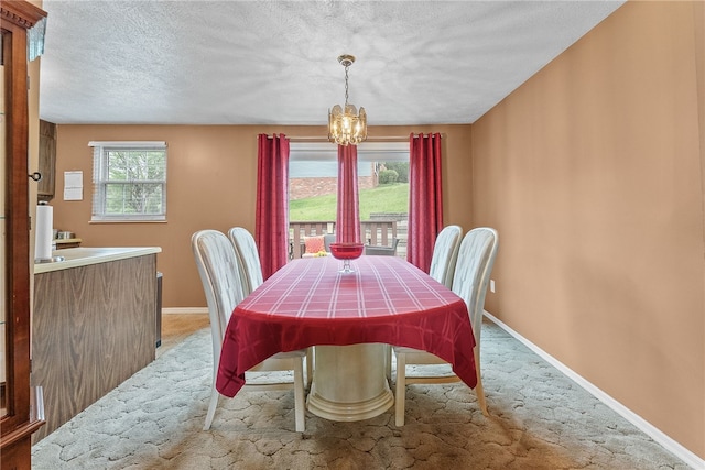 948 Broglie Dr, South Park, PA 15236 - dining area with light colored carpet, baseboards, an inviting chandelier, and a textured ceiling