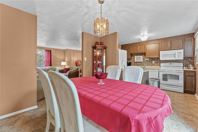 948 Broglie Dr, South Park, PA 15236 - dining space with an inviting chandelier, a textured ceiling, and baseboards