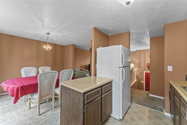 948 Broglie Dr, South Park, PA 15236 - kitchen featuring light countertops, baseboards, freestanding refrigerator, and a notable chandelier