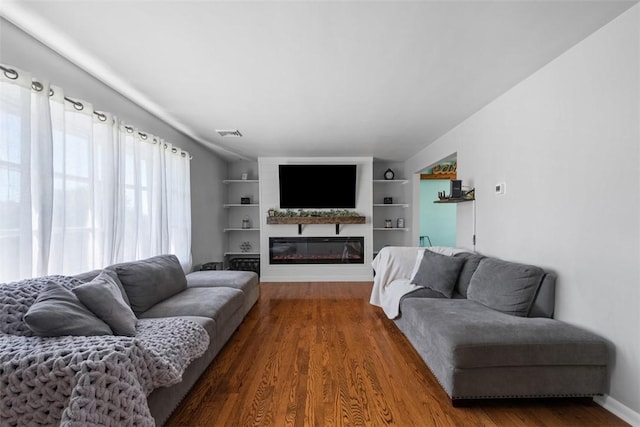 638 Morningstar Dr, Franklin Twp, PA 16117 - living area with visible vents, built in features, a glass covered fireplace, and wood finished floors