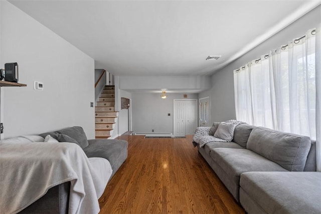 638 Morningstar Dr, Franklin Twp, PA 16117 - living room with a baseboard heating unit, visible vents, wood finished floors, and stairway