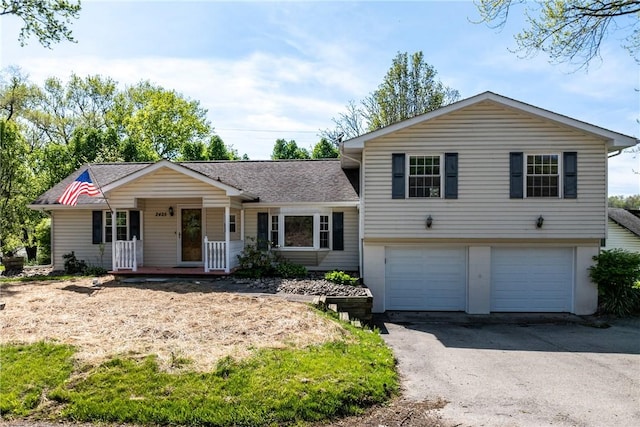 2425 Park Ave, South Franklin, PA 15301 - split level home featuring a garage, covered porch, a shingled roof, and driveway