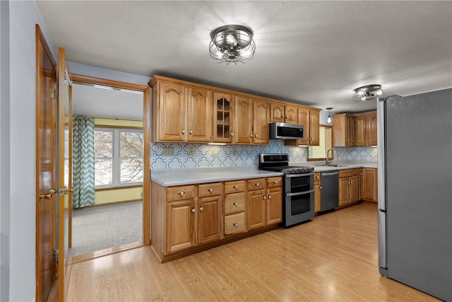 2425 Park Ave, South Franklin, PA 15301 - kitchen featuring light countertops, tasteful backsplash, a sink, light wood-style flooring, and appliances with stainless steel finishes