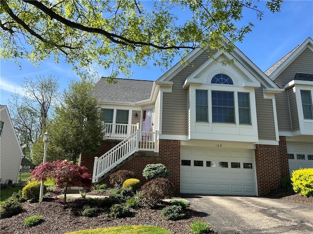 view of front of property featuring a garage, driveway, and brick siding