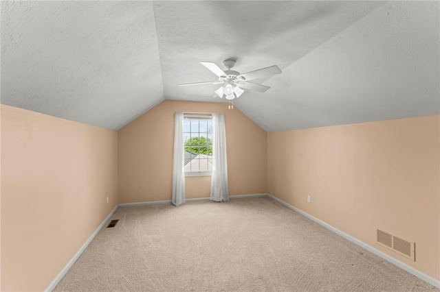 bonus room featuring ceiling fan, visible vents, baseboards, carpet floors, and lofted ceiling