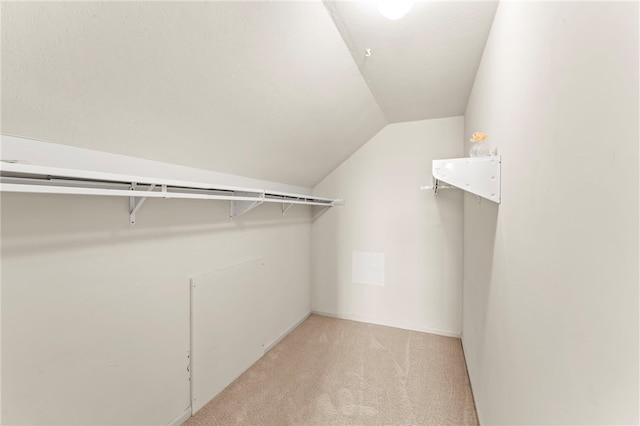 spacious closet featuring light carpet and lofted ceiling