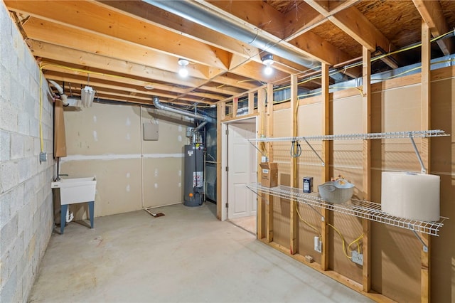 unfinished below grade area featuring water heater and concrete block wall