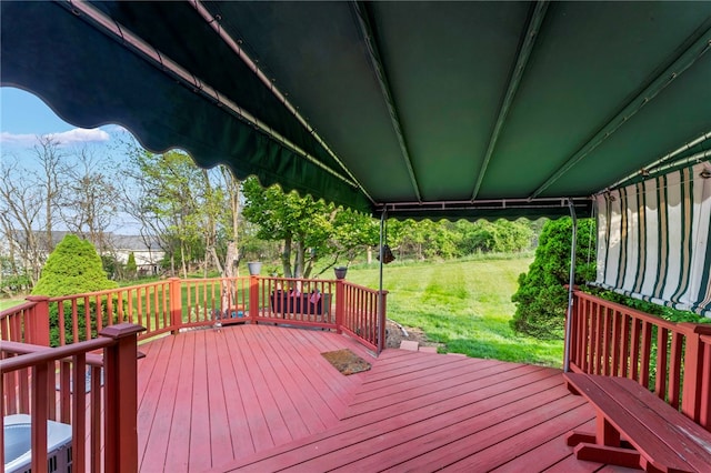 wooden deck featuring a lawn