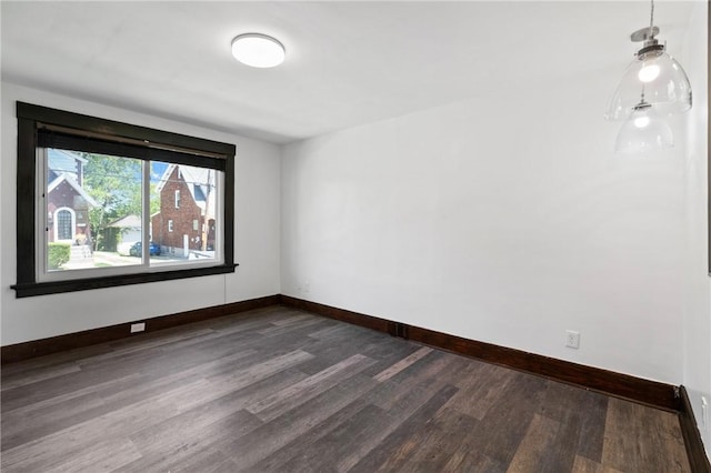 unfurnished room with baseboards and dark wood finished floors