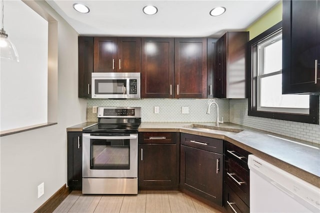 kitchen with recessed lighting, appliances with stainless steel finishes, a sink, and tasteful backsplash