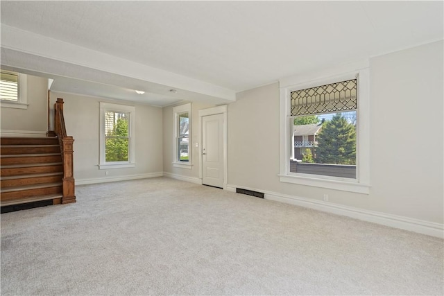 unfurnished living room with stairway, baseboards, carpet flooring, and visible vents