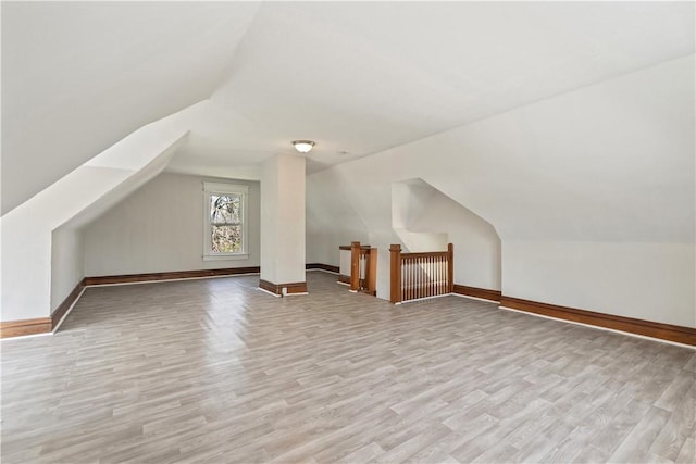 bonus room featuring baseboards, wood finished floors, and lofted ceiling