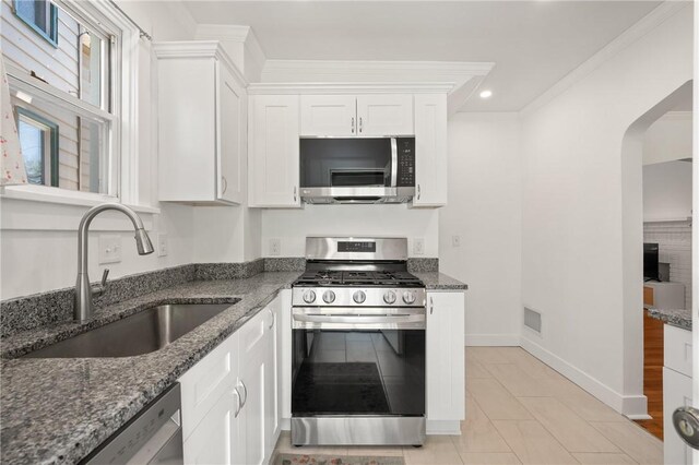 1117 Woodbourne Ave, Brookline, PA 15226 - kitchen featuring a sink, arched walkways, dark stone countertops, stainless steel appliances, and white cabinetry