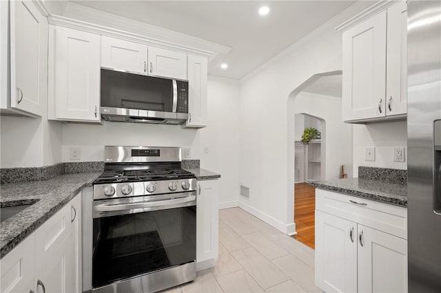 1117 Woodbourne Ave, Brookline, PA 15226 - kitchen with arched walkways, stainless steel appliances, baseboards, white cabinetry, and ornamental molding