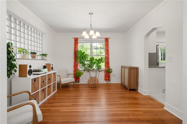 1117 Woodbourne Ave, Brookline, PA 15226 - dining room with an inviting chandelier, arched walkways, baseboards, light wood-type flooring, and ornamental molding
