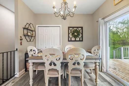 dining room with baseboards, wood finished floors, and a chandelier