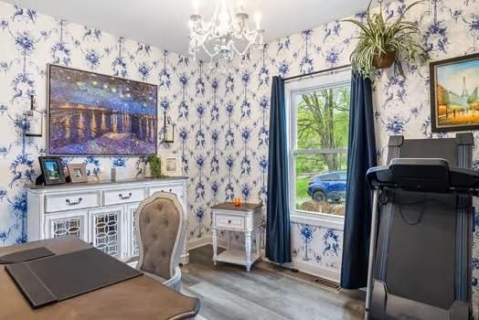 office space with wallpapered walls, a notable chandelier, baseboards, and wood finished floors