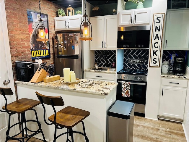 kitchen with tasteful backsplash, a breakfast bar area, stainless steel appliances, and light wood-type flooring