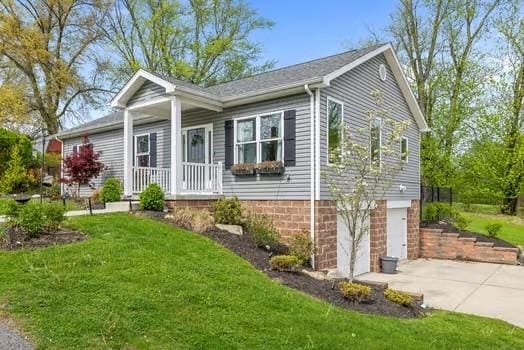 ranch-style home with an attached garage, a front lawn, and driveway