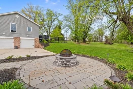 view of patio with a garage, a fire pit, and concrete driveway