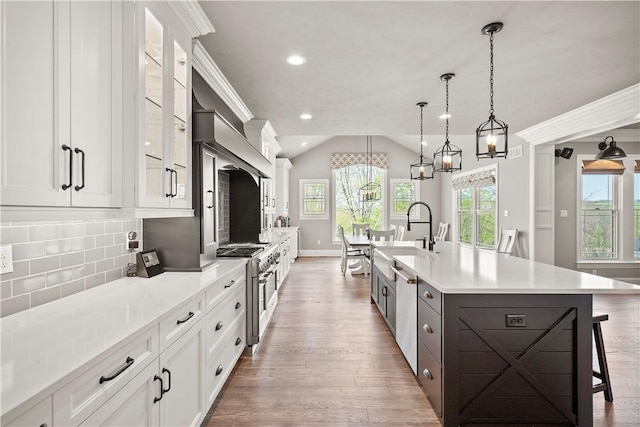 131 Woodford Dr, Adams Twp, PA 16033 - kitchen featuring appliances with stainless steel finishes, a sink, white cabinets, light wood finished floors, and a breakfast bar