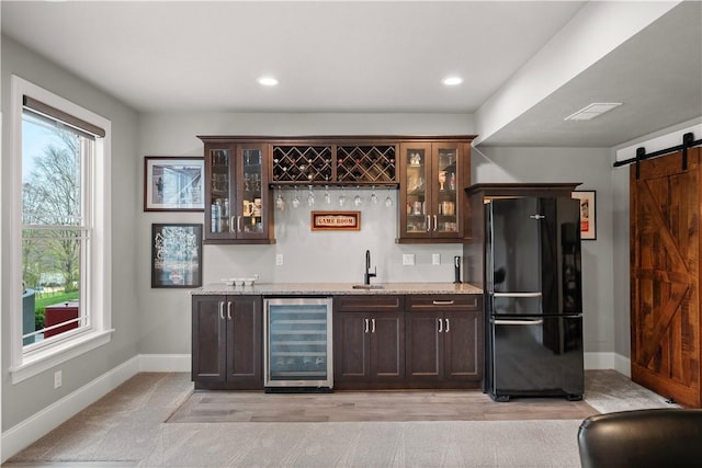 131 Woodford Dr, Adams Twp, PA 16033 - bar with a barn door, baseboards, freestanding refrigerator, indoor wet bar, and beverage cooler