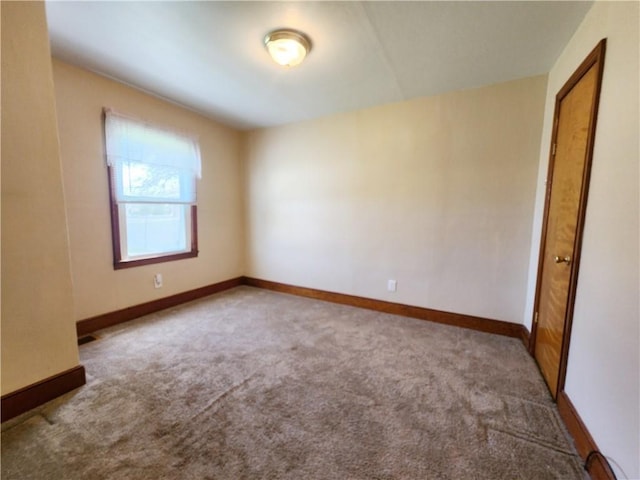carpeted spare room featuring baseboards