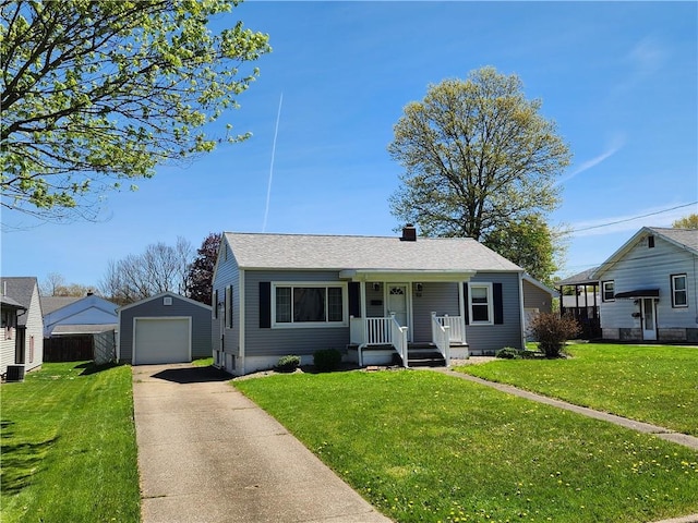 bungalow-style home with a garage, an outdoor structure, driveway, and a front lawn