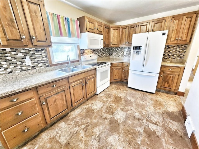 kitchen with brown cabinetry, a sink, white appliances, and tasteful backsplash