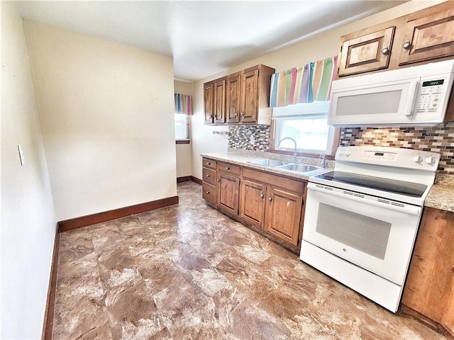 kitchen featuring a sink, decorative backsplash, plenty of natural light, and white appliances