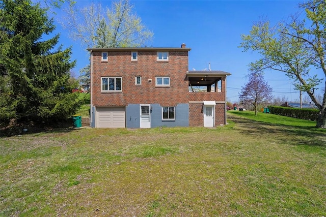 rear view of house featuring a lawn, brick siding, a chimney, and a garage