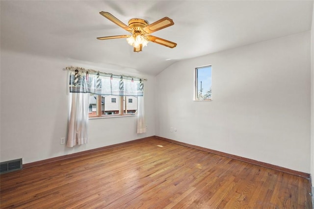 spare room with visible vents, lofted ceiling, baseboards, light wood-style floors, and ceiling fan