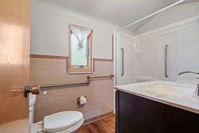 bathroom featuring wainscoting, vanity, toilet, tile walls, and wood finished floors