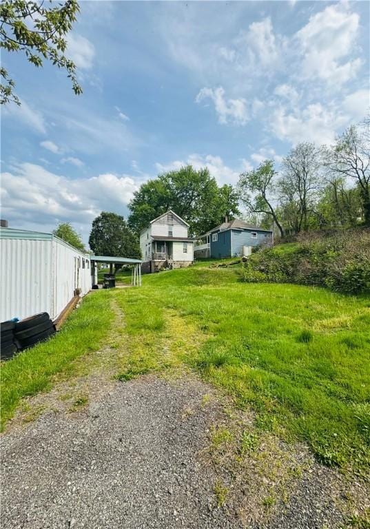 view of yard featuring a detached carport and driveway