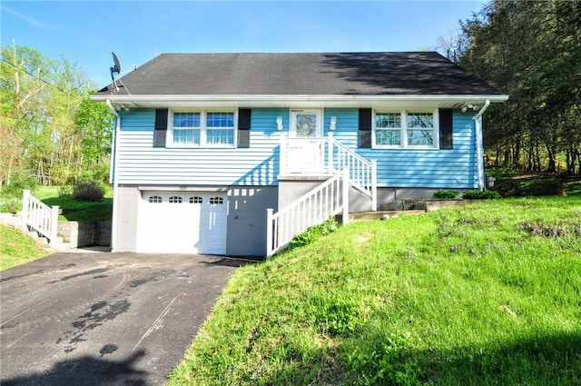 ranch-style house with an attached garage and aphalt driveway