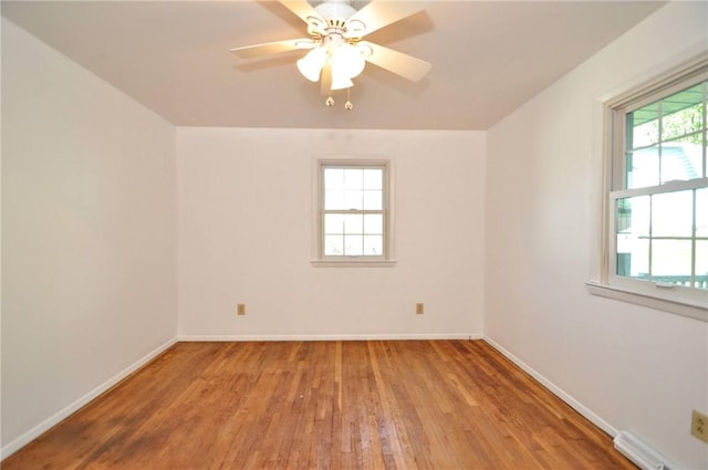 unfurnished room featuring baseboards, a ceiling fan, and hardwood / wood-style flooring