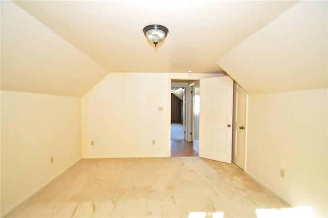 bonus room featuring baseboards, vaulted ceiling, and light carpet