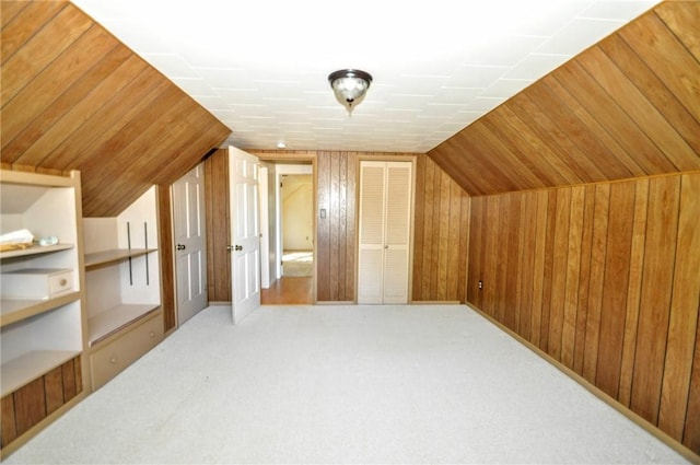 bonus room featuring wooden walls, carpet flooring, and lofted ceiling