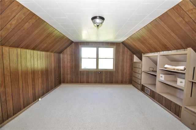 bonus room with wooden walls, vaulted ceiling, and carpet flooring