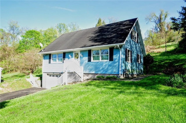 view of front of home with an attached garage, driveway, and a front yard