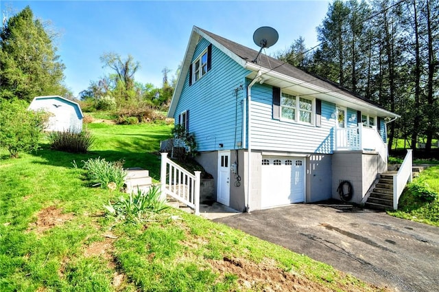 view of home's exterior featuring an attached garage, a yard, driveway, and stairway