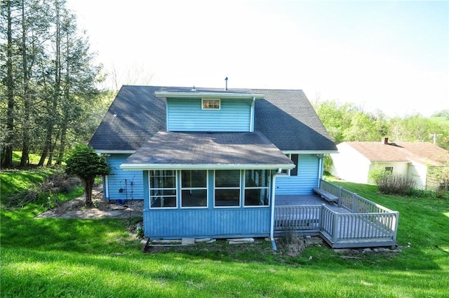 back of property featuring a lawn, a wooden deck, and roof with shingles