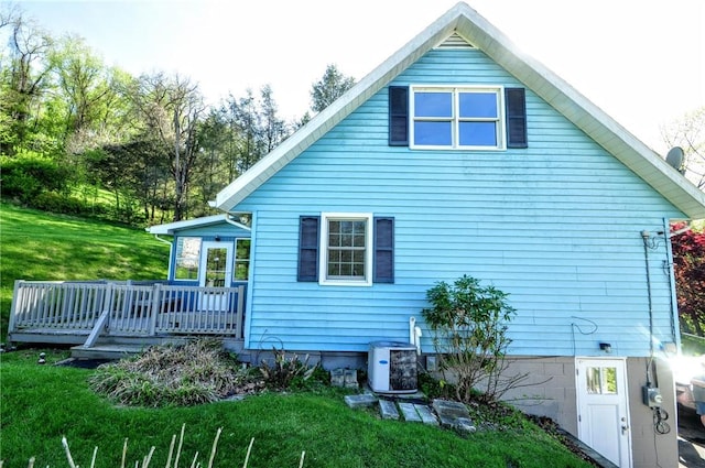 back of house with central air condition unit, a lawn, and a wooden deck