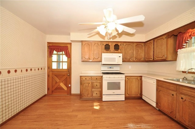kitchen featuring light countertops, a sink, white appliances, and wallpapered walls