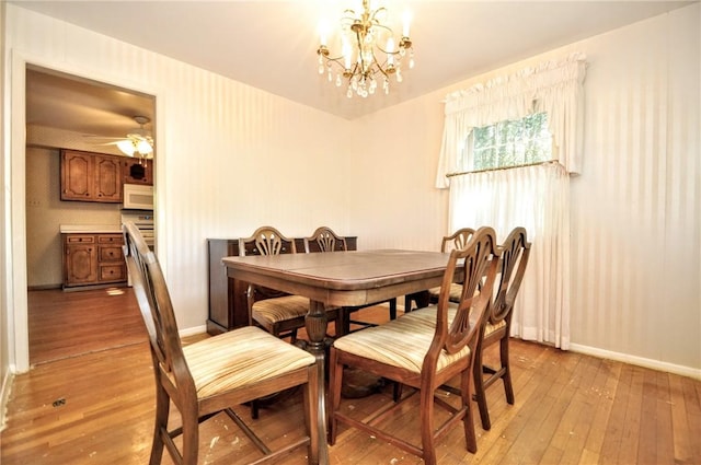 dining room with baseboards, light wood finished floors, and ceiling fan with notable chandelier