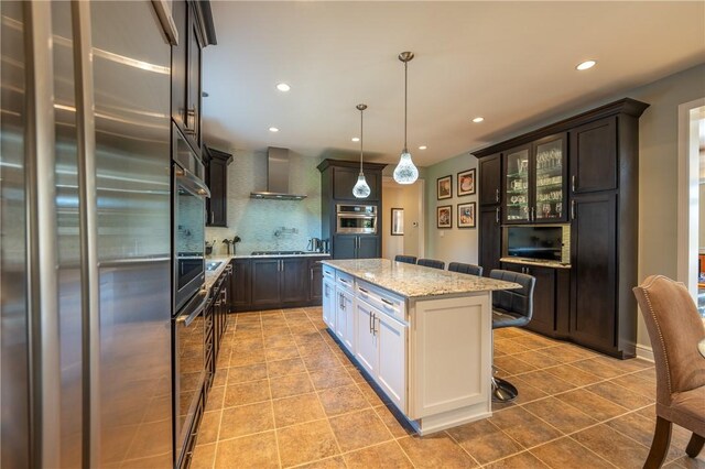 kitchen with glass insert cabinets, high quality fridge, wall chimney exhaust hood, light tile patterned floors, and backsplash