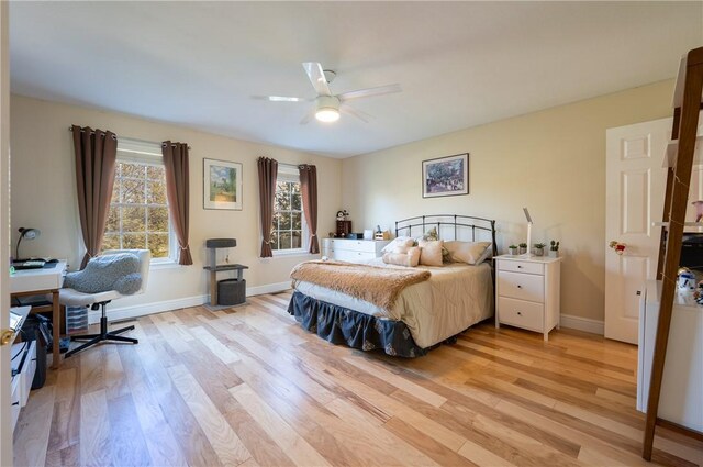 bedroom with baseboards, ceiling fan, and light wood-style flooring