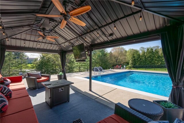 outdoor pool with ceiling fan, a patio area, a gazebo, fence, and an outdoor hangout area
